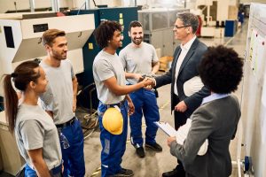 heureux-directeur-entreprise-serrant-main-travailleur-noir-apres-reunion-du-personnel-dans-usine