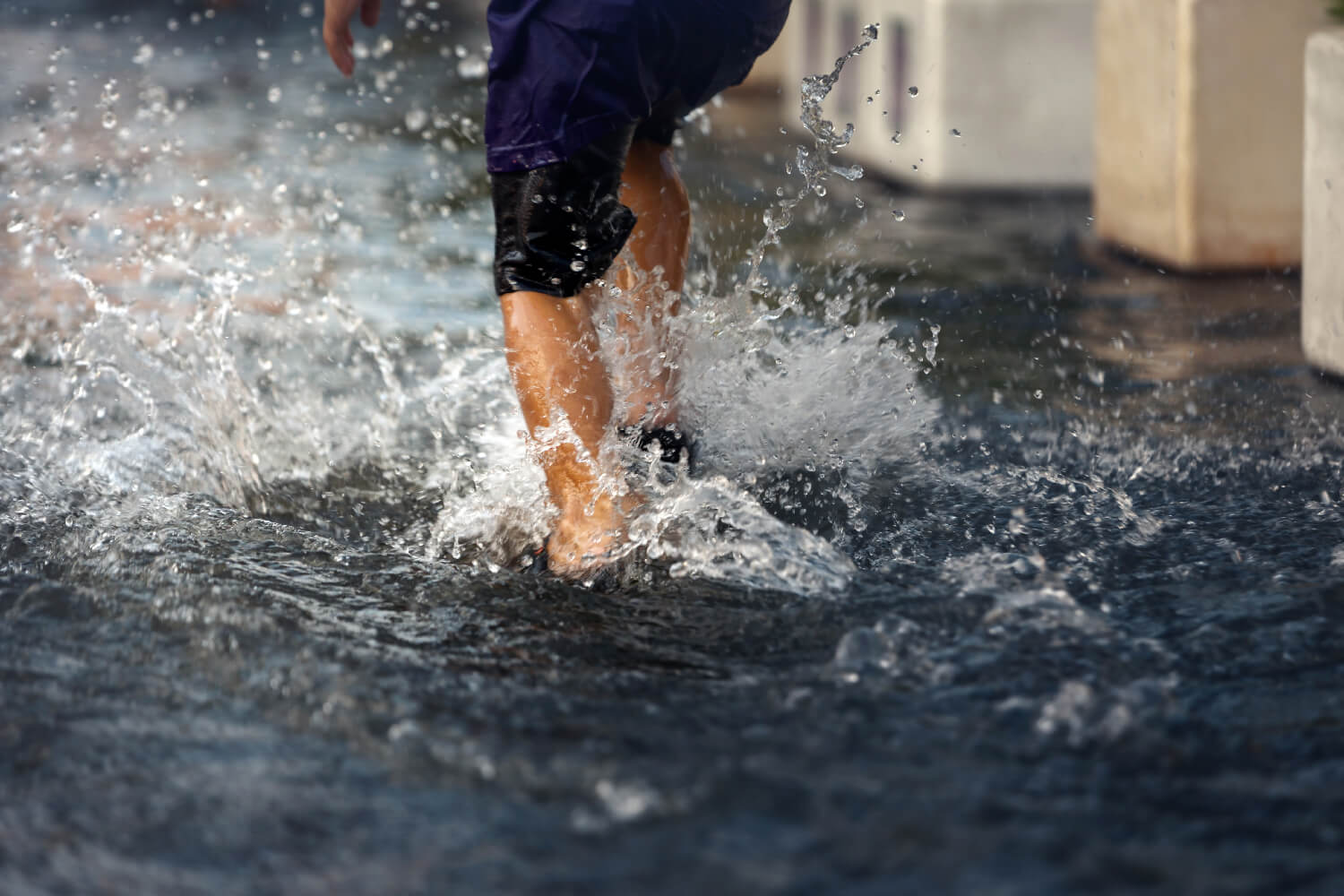 vue-angle-bas-enfants-asiatiques-s-amusant-jouer-pluie-route-inondee